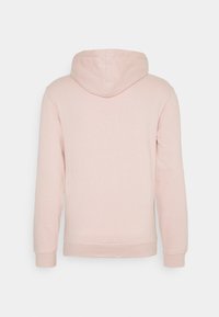 Sudadera con capucha de color rosa, con una textura suave, mangas largas y una capucha grande. Diseño simple con puños y cinturilla acanalados, sin hardware visible.