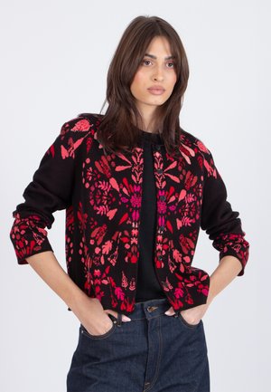 Black cardigan featuring a floral pattern in red and pink hues, with a round neckline and button closures, paired with a black top.