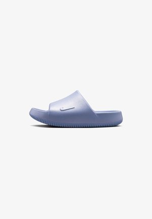 Jasnofioletowa sandałka Nike typu slide z teksturowaną podeszwą i wypukłym logo swoosh na pasku, pokazana z boku na białym tle.