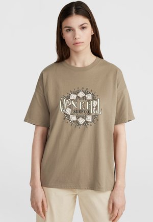 Bruine katoenen T-shirt met korte mouwen en een ronde halslijn. Heeft een circulair grafisch logo in zwart en wit, met een tribaal ontwerp.