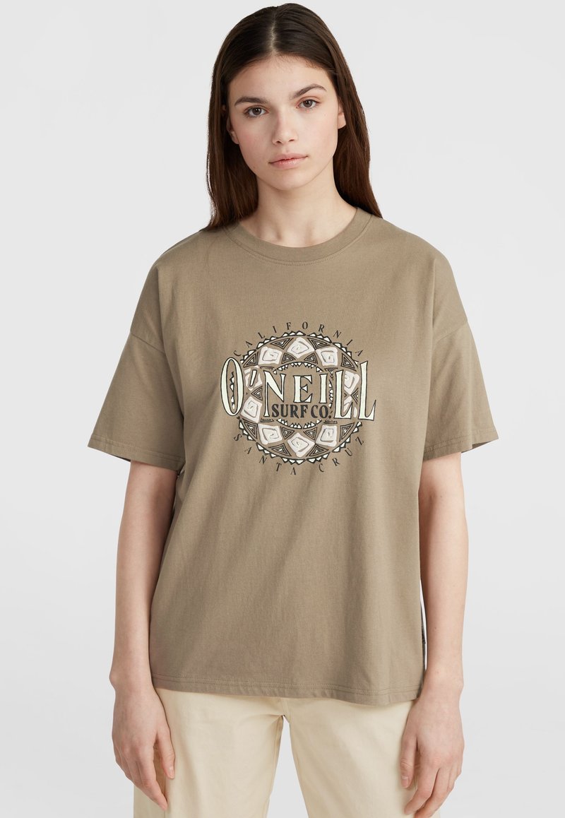 Bruine katoenen T-shirt met korte mouwen en een ronde halslijn. Heeft een circulair grafisch logo in zwart en wit, met een tribaal ontwerp.