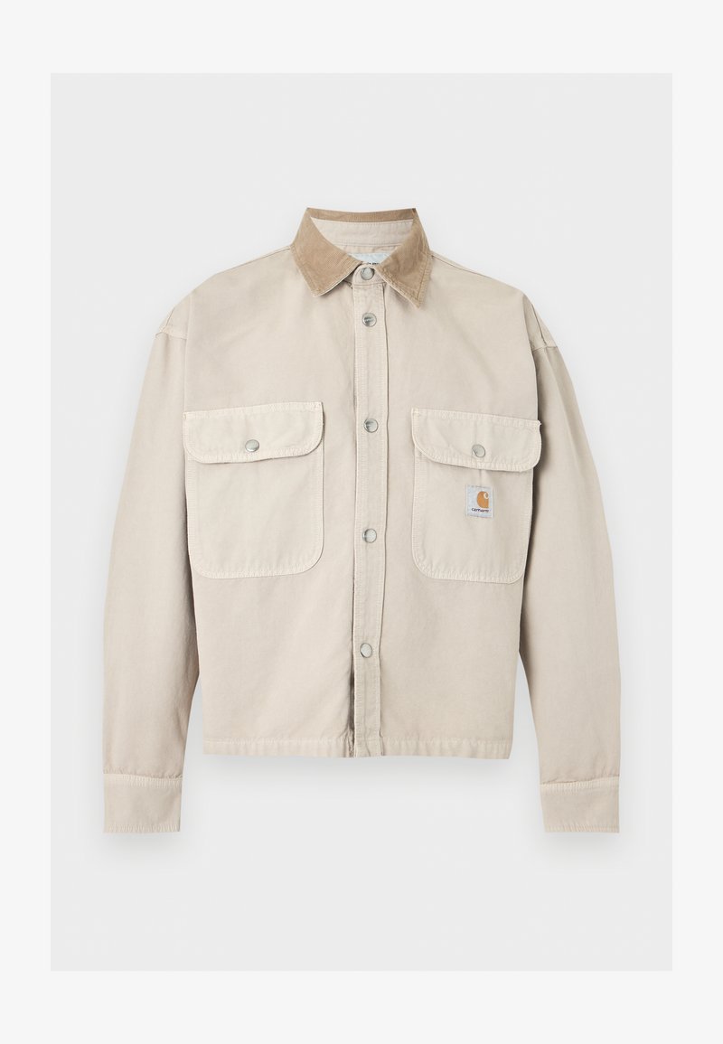 Beige knöpfbare Jacke mit zwei aufgesetzten Fronttaschen und einem kontrastierenden hellbraunen Kordkragen, mit einem kleinen Logopatch auf der rechten Tasche.