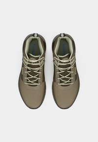 Hnedé turistické topánky s hladkým povrchom, s bledohnedými šnúrkami a polstrovaným golierom. Logo Timberland viditeľné na boku.