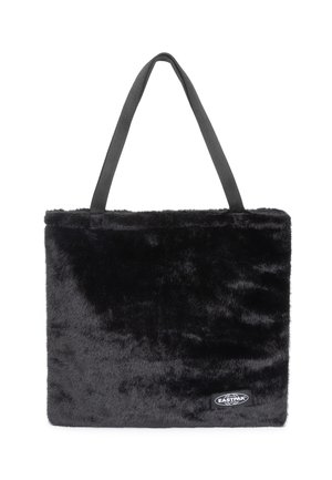 Svart fuskpäls tote-väska med grå handtag, rektangulär form, mjukt material och en liten svart etikett på framsidan.