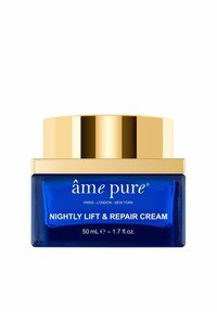 Blå glasburk med ett lock i guld. Etiketten lyder "âmê pure" och "NIGHTLY LIFT & REPAIR CREAM," med 50 mL produkt.