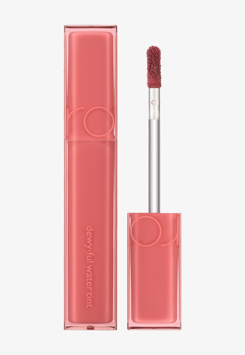 Tubo rettangolare rosa con corpo trasparente e applicatore argento. Prodotto etichettato "dewy.full water tint." Texture morbida con punta dell'applicatore pelosa.