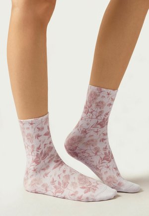Calze alla caviglia con motivo floreale in rosa chiaro, realizzate in un materiale morbido ed elastico, e con un polsino a costine, caratterizzate da un delicato design di rose e foglie.