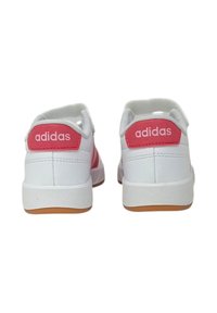 Sneaker bianche con accenti rosa, caratterizzate da una finitura testurizzata, suola piatta e marchio 'adidas' sul tallone e sul lato.