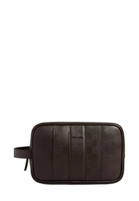 Trousse de toilette en cuir marron avec panneaux lisses et texturés, dotée d'un logo discret et d'une poignée latérale pour un transport facile.