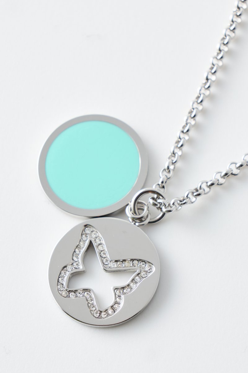 Silberkettchen-Halskette mit zwei runden Anhängern, einem in Türkis und einem mit Schmetterling-Ausschnitt, umgeben von kleinen klaren Steinen.