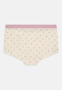 Culotte en coton avec une taille élastique rose doux, présente un fond crème et des motifs de petites fleurs roses dispersés. Design extensible et confortable.