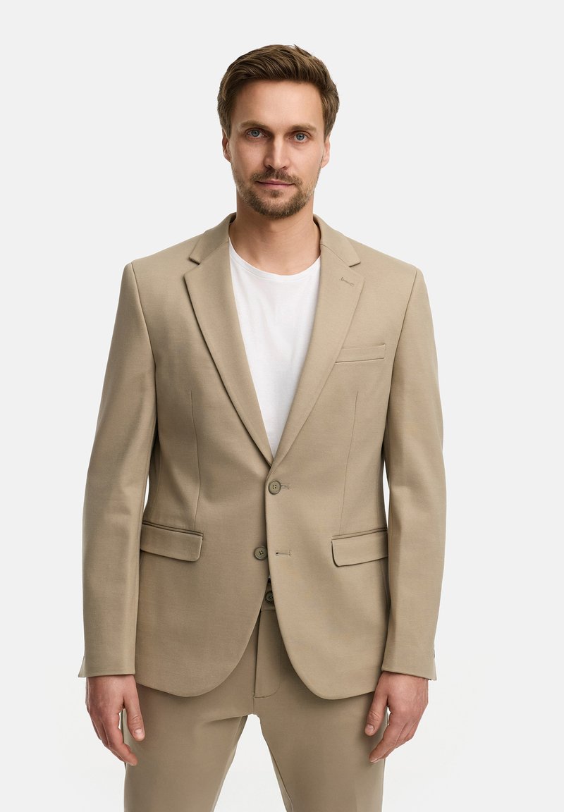 Beige Sakko mit zwei Knöpfen, Reverskragen und seitlichen Taschen. Aus glattem Stoff, kombiniert mit einem weißen Rundhals-T-Shirt.