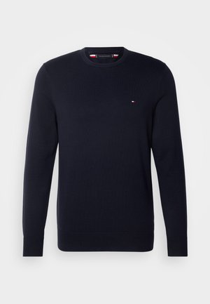 Mørkeblå strikket sweater med rund halsudskæring, ribbede manchetter og kant, samt et lille logo i rød, hvid og blå på venstre bryst.