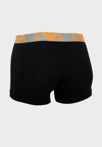 Schwarze Boxer-Shorts mit einem grauen Bund und orangefarbener Markenbezeichnung. Der Stoff wirkt glatt, hat eine enge Passform und keine sichtbaren Muster.