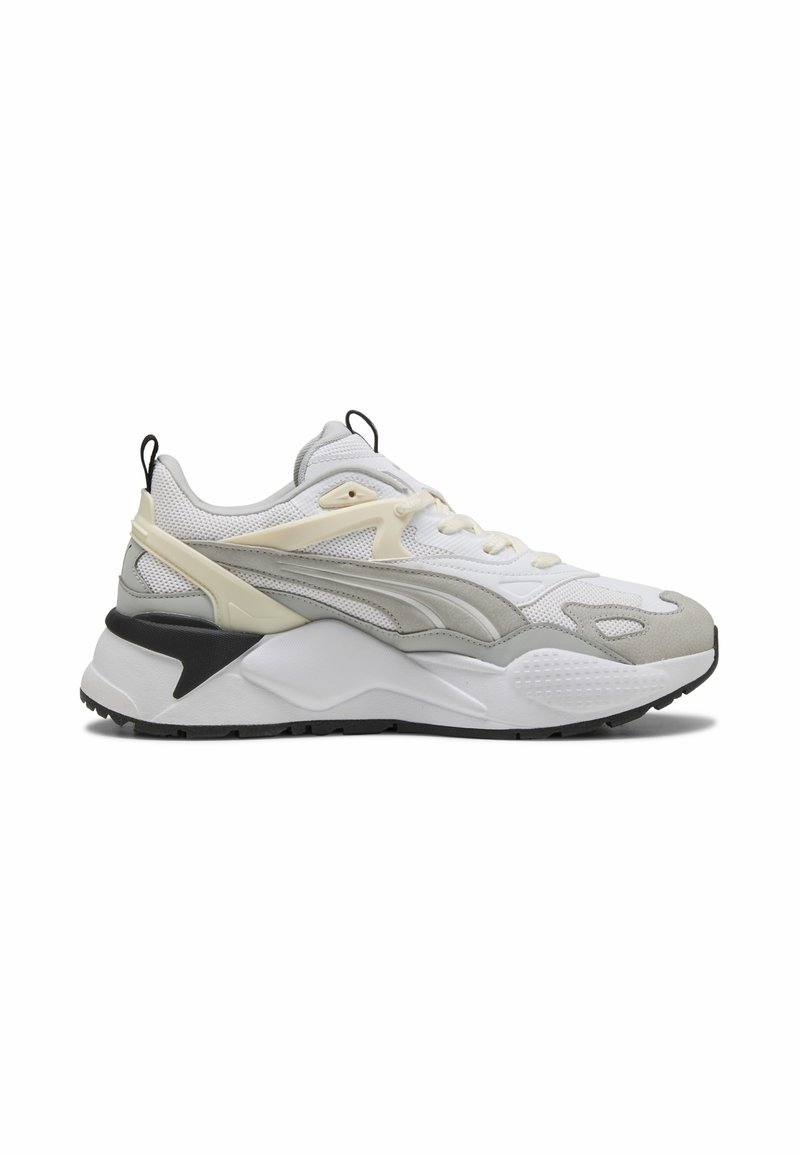 Białe i szare sneakersy z siateczkowym wierzchem, teksturowanymi akcentami, grubą podeszwą i czarnym detalem na pięcie. Posiadają kontrastowe nakładki i system sznurowania.