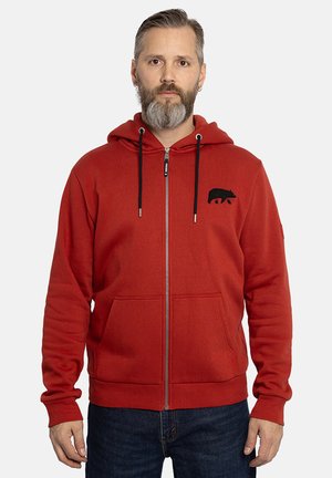 Felpa rossa con zip, dotata di tasca a marsupio frontale, emblema di un orso nero sul petto, cappuccio regolabile con cordino e polsini a costine.