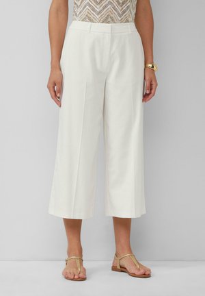 Pantalons blancs à jambe large avec une texture lisse et une coupe ajustée, présentant une taille mi-haute et de subtils plis devant.