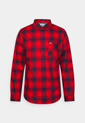 Camisa de cuadros rojos de manga larga hecha de algodón. Presenta un cuello con botones, un bolsillo frontal con un patrón diagonal y acentos negros.