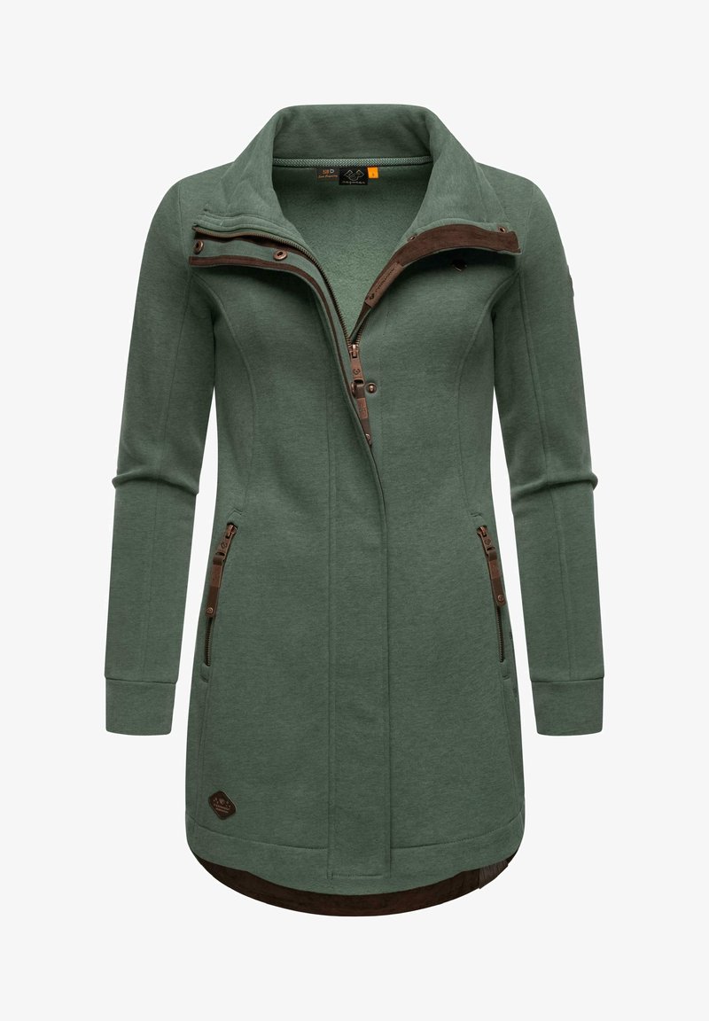 Zöld fleece dzseki magas gallérral, cipzáros elülső résszel és két oldalsó zsebbel. Barna részletekkel és ívelt himmel a testhezálló illeszkedésért.