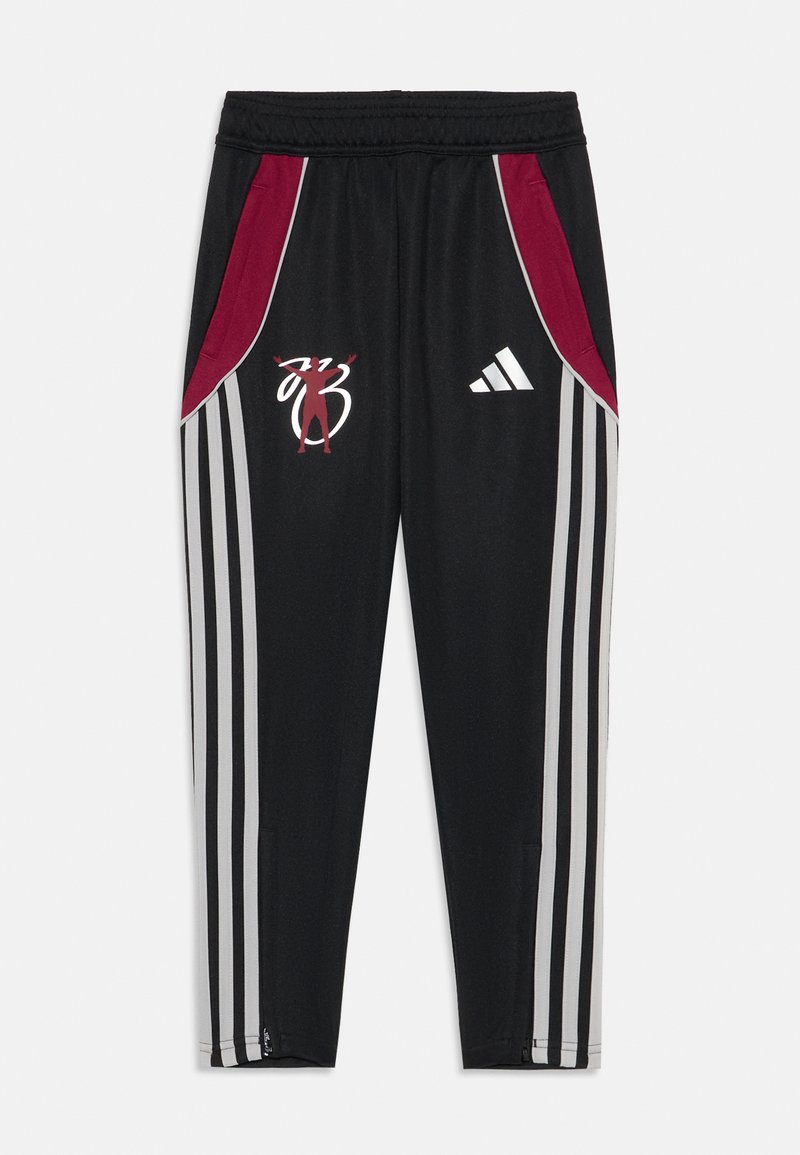 Pantalones deportivos negros con paneles laterales rojos, tres franjas blancas en cada pierna, un logo bordado y aperturas con cremallera en los tobillos.