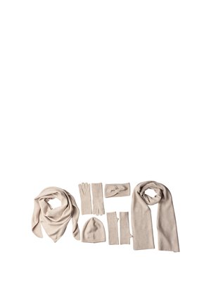 Accessoires d'hiver beige doux comprenant deux écharpes, deux paires de gants, un bonnet, des mitaines sans doigts et un bandeau tricoté sur fond blanc.