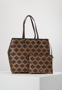 Brązowa wzorzysta torba na ramię z dwoma uchwytami, ozdobiona geometrycznym wzorem i małą dopasowaną saszetką. Teksturowana powierzchnia z delikatnym połyskiem.