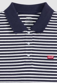 Navyblå och vit randig pikétröja med en enfärgad krage, tre knappar fram och en röd Levi's-logotyp på vänster bröst.