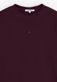 Bordeaux t-shirt van zacht katoen, met een ronde hals en een klein roze doodskop en kruisbotten logo op de borst.