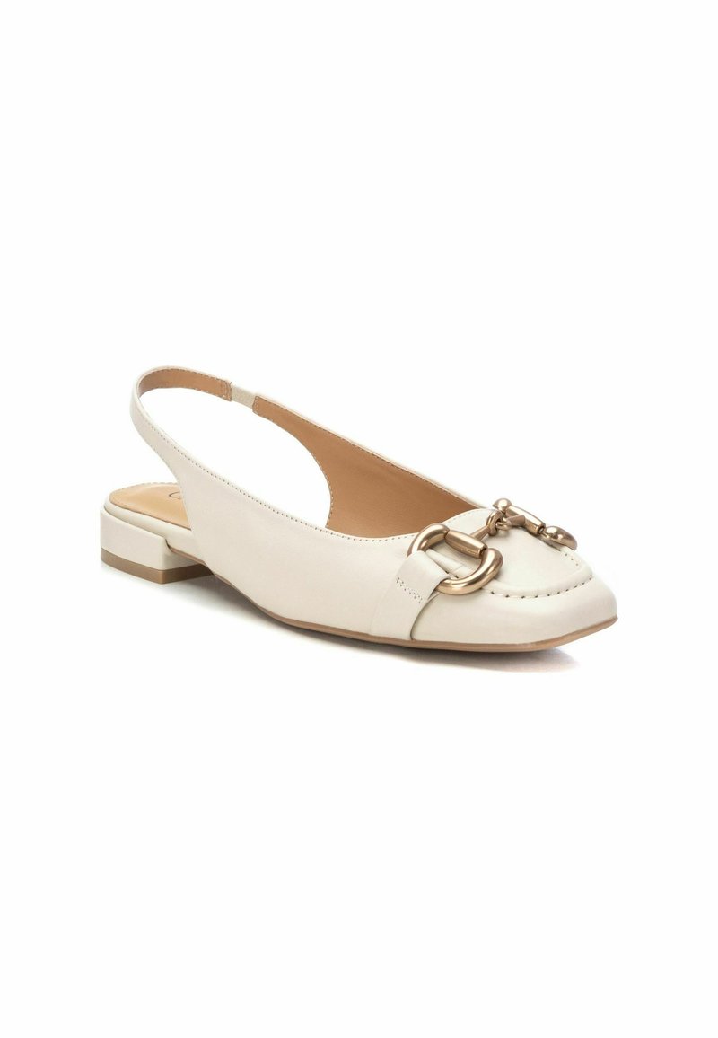 Chaussure plate slingback en cuir beige avec un bout rond, un petit talon bloc, un détail en chaîne dorée à l'avant et une texture lisse.