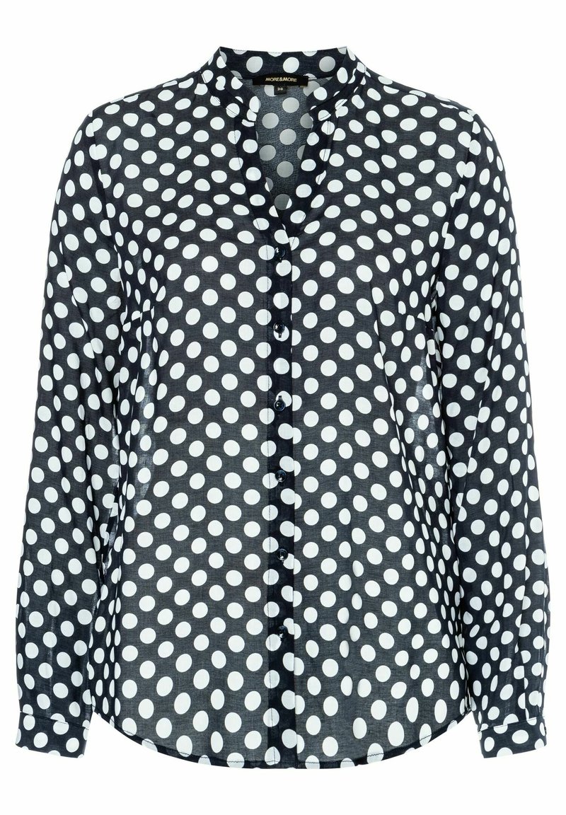 Camicia nera con pois bianchi, maniche lunghe, chiusura a bottoni, colletto alla Mandarin e orlo leggermente curvato. Tessuto leggero e liscio.