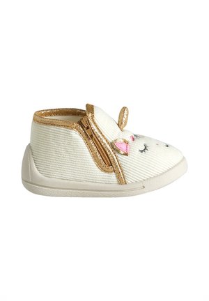 White toddler shoe with gold trim, side zipper, and unicorn face design featuring ears, closed eyes, and pink details on the front.