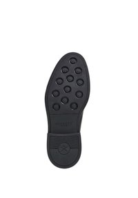 Suola di scarpa in gomma nera con molteplici schemi di grip circolari; presenta la scritta "HACKETT LONDON" impressa sul tallone e una striscia orizzontale texture.