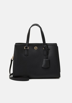 Sac à main en cuir noir Michael Kors avec deux poignées, logo doré et bandoulière ajustable sur un fond clair uni.