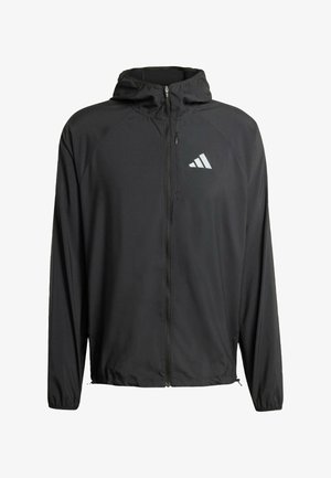 Zwarte lichte gevoerde jas met een volledige rits, voorzien van een grijze Adidas-logo op de linkerborst en elastische manchetten. Glad, ademend materiaal.