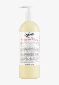 Crème de Corps de Kiehl's, 500 mL, bouteille en plastique beige avec un distributeur à pompe, présente un texte noir et une étiquette blanche détaillant les ingrédients et l'utilisation.