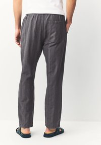 Gray lightweight pants with an elastic waistband and a single rear pocket. Features a subtle textured pattern and a straight-leg design.