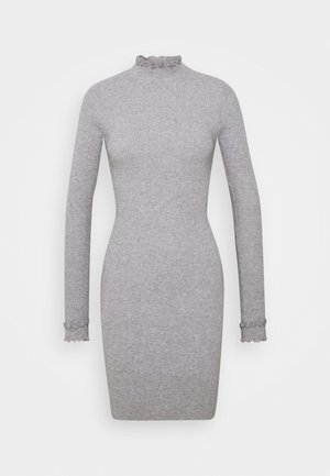 Robe grise côtelée avec un col volant haut et des manches longues, dotée de poignets festonnés. Fabriquée en tissu doux et extensible.