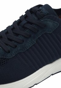 Sneaker blu navy con tomaia in rete testurizzata e suede, caratterizzato da lacci piatti, design rigato e suola in gomma bianca.