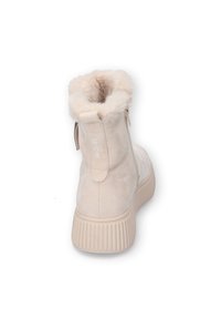 Beige Wildleder-Ankle Boots mit Kunstfellfutter, einer gerippten Sohle und einem seitlichen Reißverschluss für einfaches An- und Ausziehen.