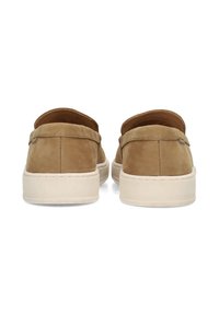 Zapatos tipo slip-on de ante marrón con una suela de goma beige, que presentan un perfil bajo, detalles de costura y una abertura en el talón para facilitar su uso.