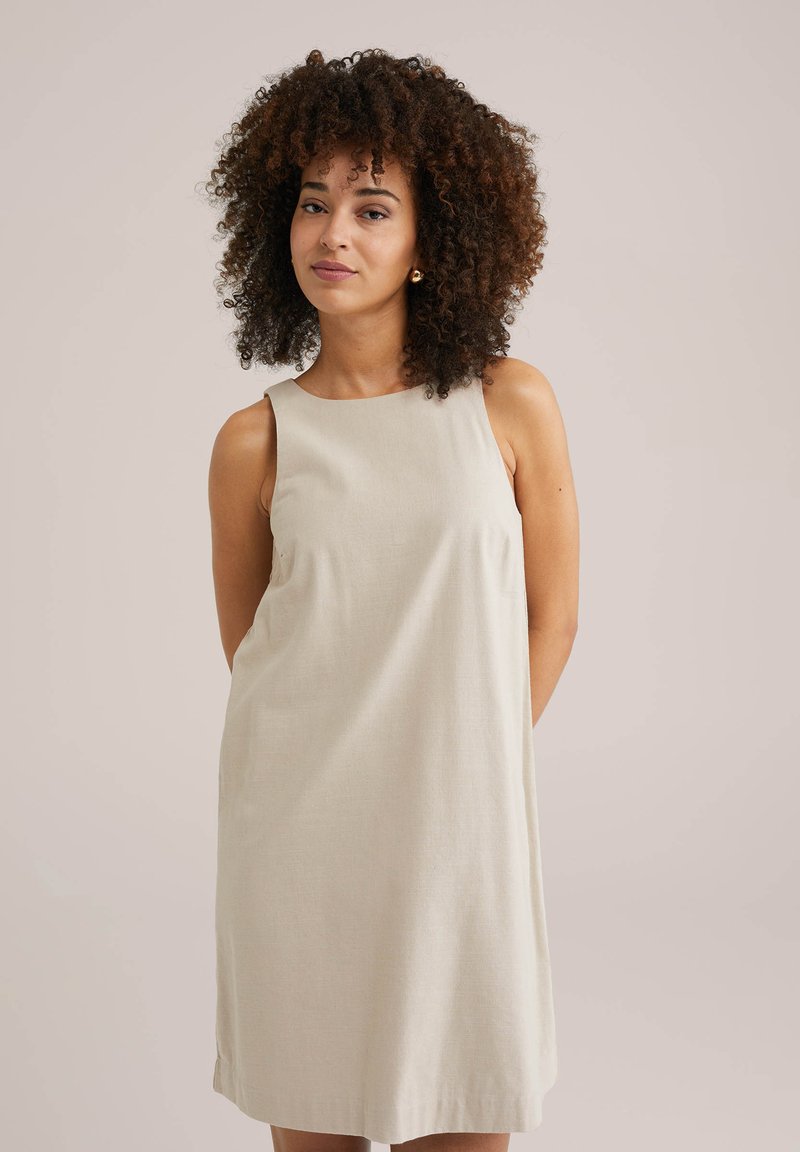 Rochie din in bej, fără mâneci, cu o croială lejeră. Gât rotund și detalii de cusătură minime. Textură netedă și design până la genunchi.