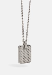 Collar de plata con colgante rectangular que presenta un patrón de diamantes texturizados, unido a una cadena trenzada.