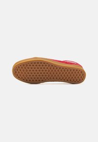 Scarpa rossa in suede con suola in gomma testurizzata caratterizzata da un motivo a rombi, che offre aderenza e durabilità. Design piatto con minimi accenti.