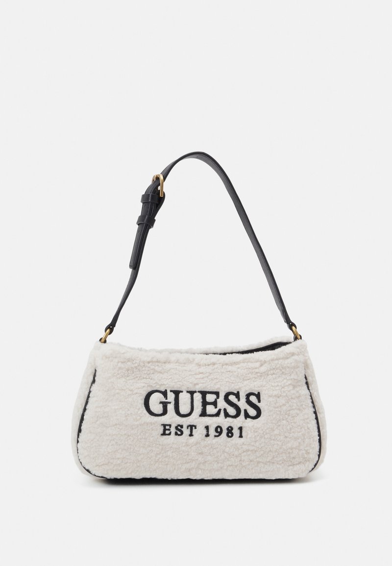 Witte pluche handtas met een zwarte leren band en goudkleurige hardware. "GUESS EST 1981" is in het zwart op de voorkant geborduurd. Rechthoekige vorm.