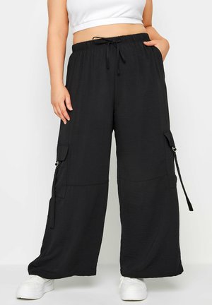 Pantalons cargo noirs à jambes larges, fabriqués en tissu léger, dotés de poches latérales, d'une taille élastique avec cordon de serrage et d'une coupe décontractée.