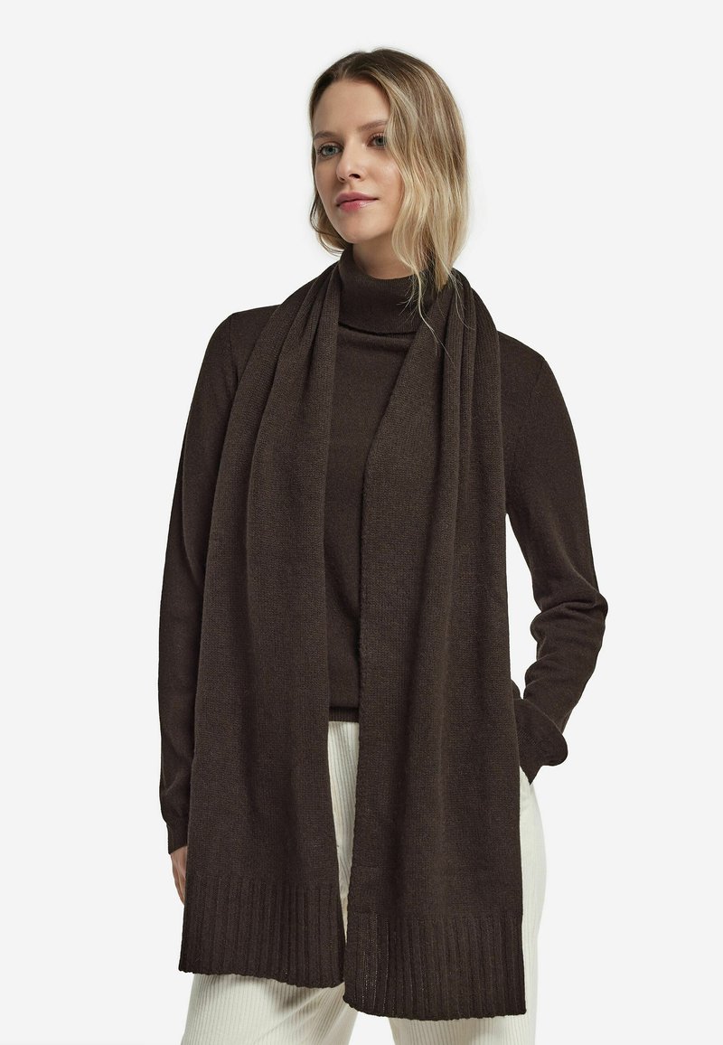 Mørkebrun tørklæde lavet af blødt, tekstureret stof. Har en ribbet kant og hænger elegant, hvilket komplementerer en højhalset top.