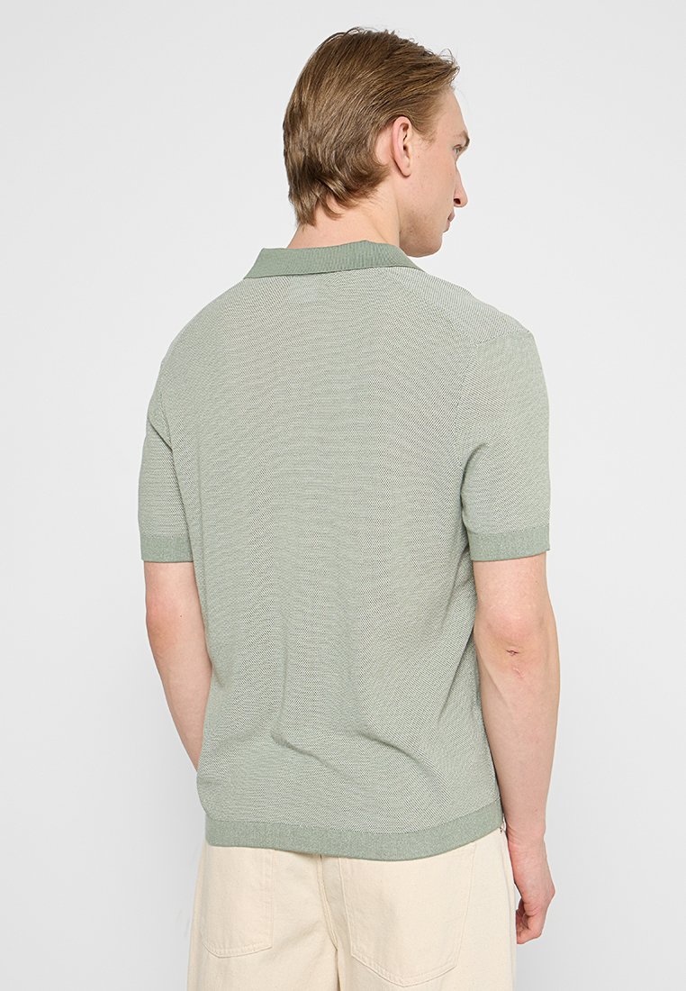 Kurze Ärmel Poloshirt in hellgrün, aus strukturiertem Strickstoff, mit einem gerippten Kragen und Saum, der ein dezentes Muster aufweist.
