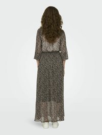 Abito maxi in tessuto trasparente, con uno sfondo nero e piccoli motivi floreali, maniche a tre quarti e vita sfiancata.