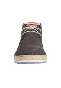 Grijze suède sneaker met beige rubberen zool, gestructureerde bovenkant en lichtgekleurde veters. Heeft een ronde neus en gestikte details op de zool.