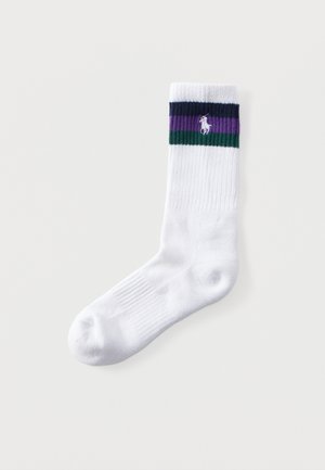 Chaussette blanche montante avec texture côtelée et bandes bleu marine, violettes et vertes près du bord-côte, avec un petit logo de cheval blanc brodé.